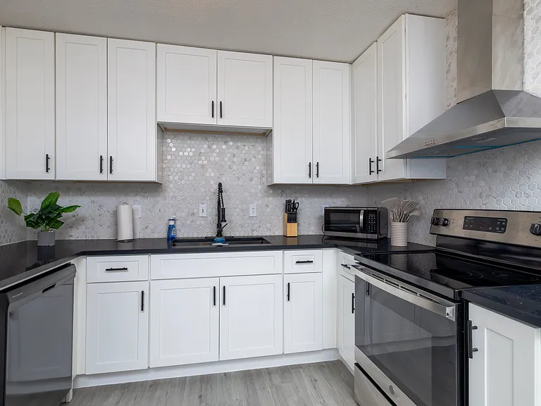 Fully stocked kitchen with a stainless steel range hood and cooking essentials