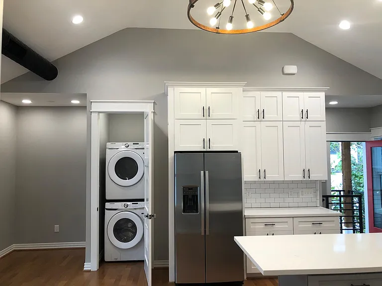 new stackabe washer and dryer in-unit with plenty of storage in kitchen