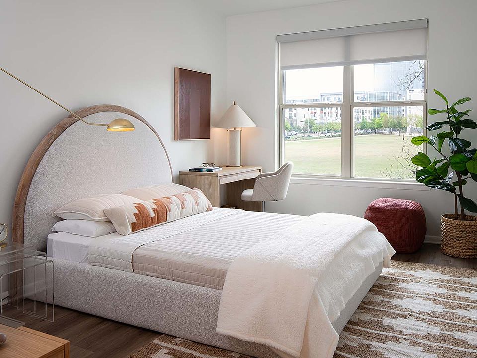 Spacious apartment bedroom with wood-style flooring.