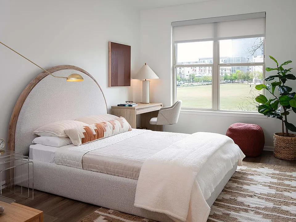 Spacious apartment bedroom with wood-style flooring.