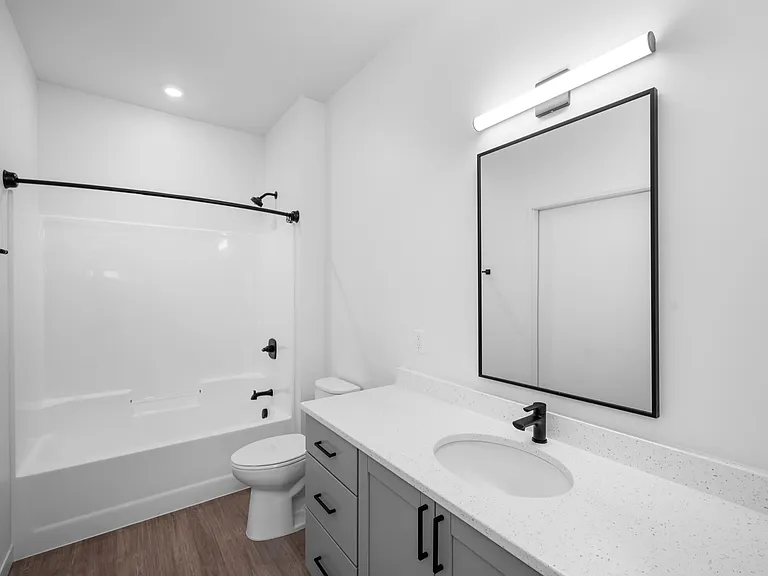 Elegant bathroom showcasing a modern white vanity, sleek black fixtures, and a pristine bathtub with overhanging shower rod. Elegant bathroom showcasing a modern white vanity, sleek black fixtures, and a pristine bathtub with overhanging shower rod.