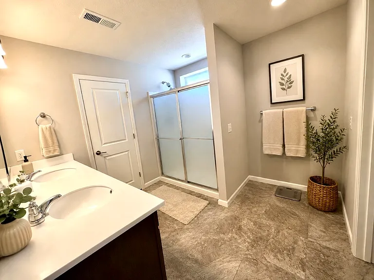 Master bathroom with an two spacious walk in closets as well as a toilet with a door