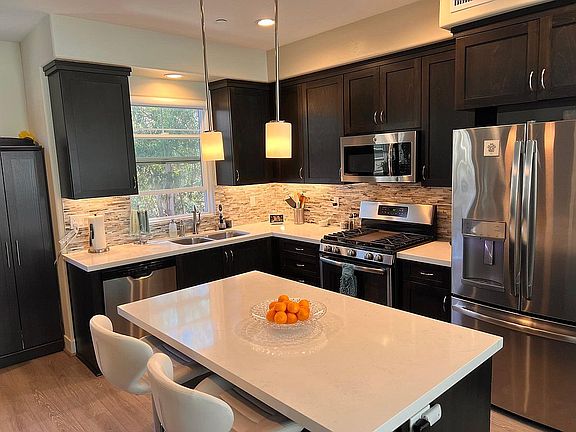 Designer kitchen with quartz countertops, custom backsplash and shaker-style cabinets