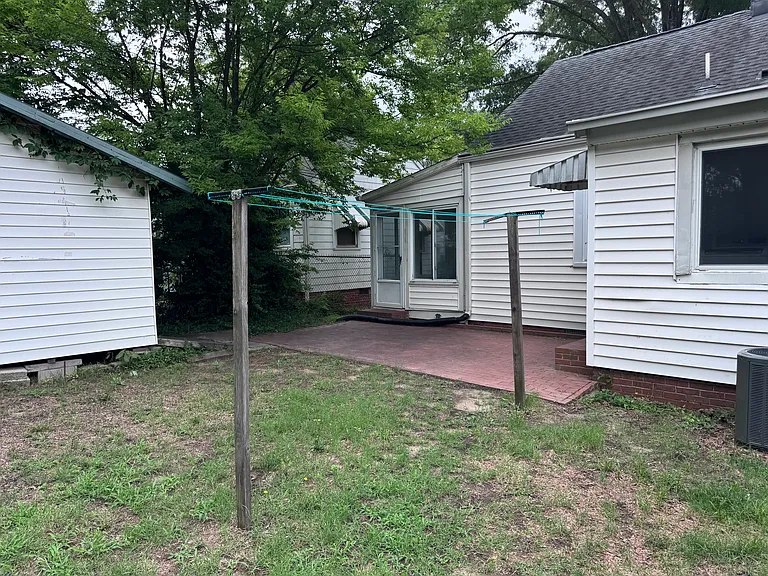 Backyard brick patio and shed that can be used for storage.