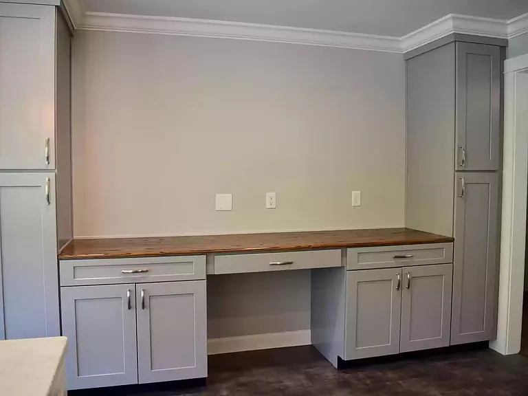 Built-in desk with cabinetry in the kitchen area.
