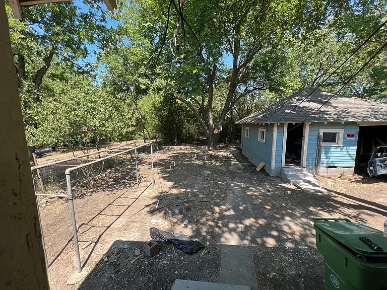 Rear yard looking east and 1car garage with extra storage units beside it and behind it.