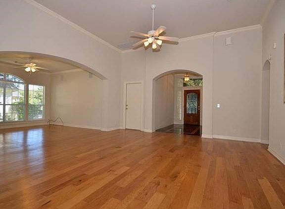 This is another view of the living room and shows the entry door, foyer plus the dining area through the arched opening on the left.
