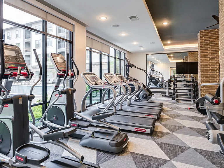Spacious Fitness Center With Cardio Machines and Pool Views