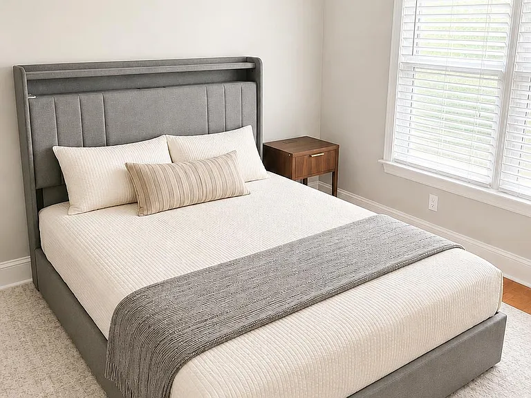 Furnished bedroom with a queen bed, upholstered headboard, nightstand, and a spacious reach in closet for ample storage.