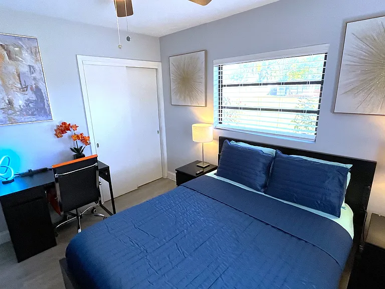Room 2 features: Queen bed, dual night stands, table lamps, ceiling fan, mini fridge, desk, 65in TV