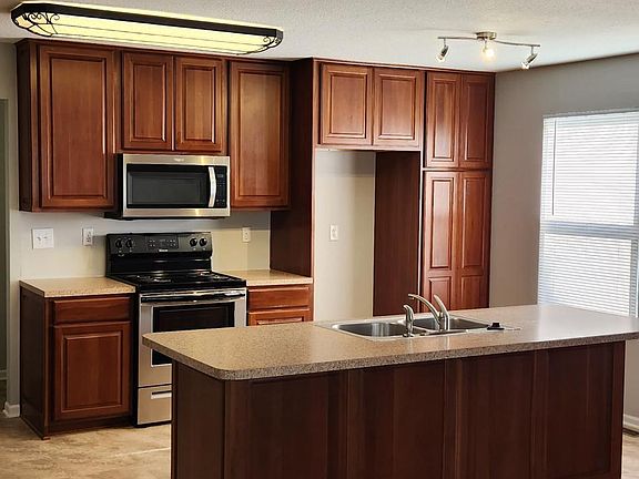 Natural light fills this open kithcen with plentiful cabinets and stainless steel stove,microwave and dishwasher.