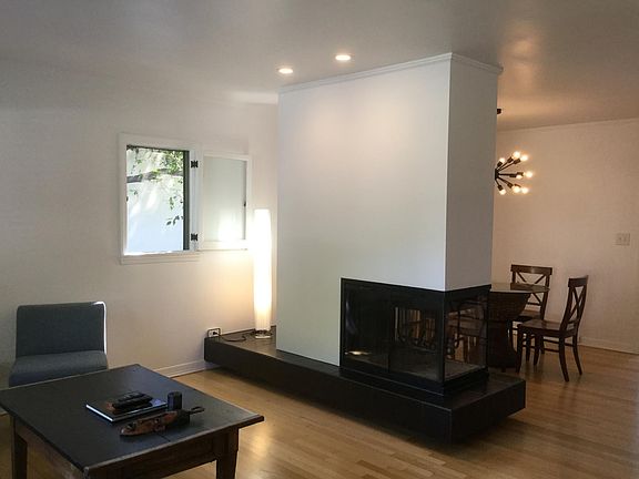 Spacious living room with three sided wood burning fireplace.