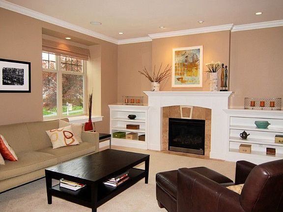 Formal living room features high ceiling with crown moulding, gas fireplace & built-in shelving