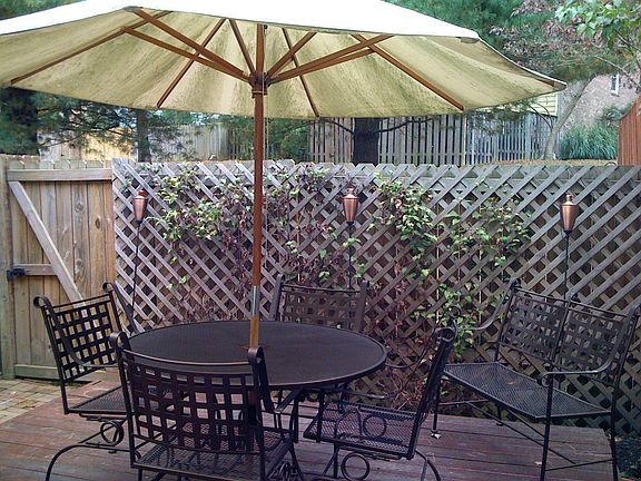 Hardscaped backyard with ground-level deck and brick paths