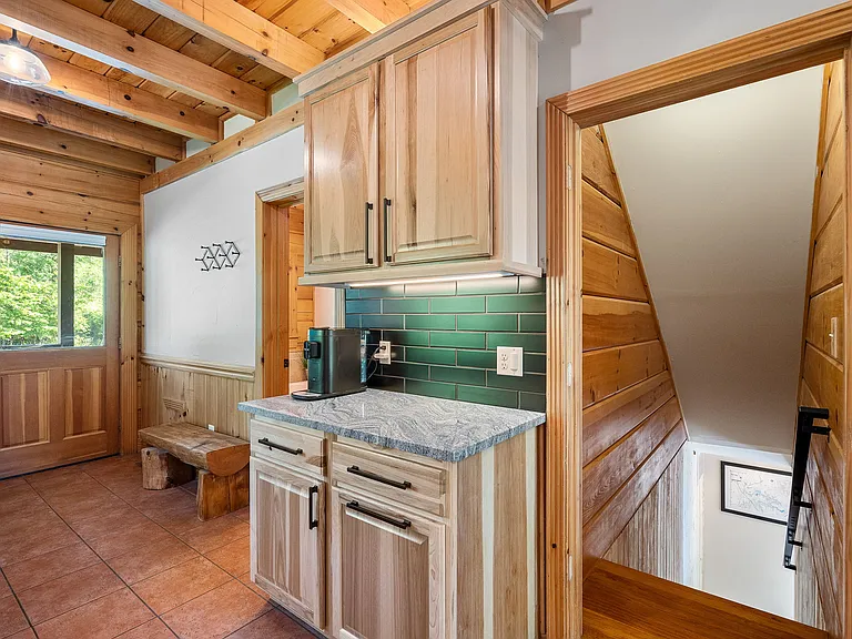 Kitchen: extra storage and coffee bar. Main floor bathroom is to the left while the stairs lead to the lower level.
