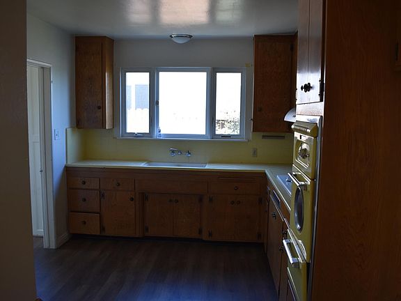 Kitchen Original cabinetry, tile, oven. Cabinetry has been resurfaced, stove top replaced 2016, blinds installed not shown here.