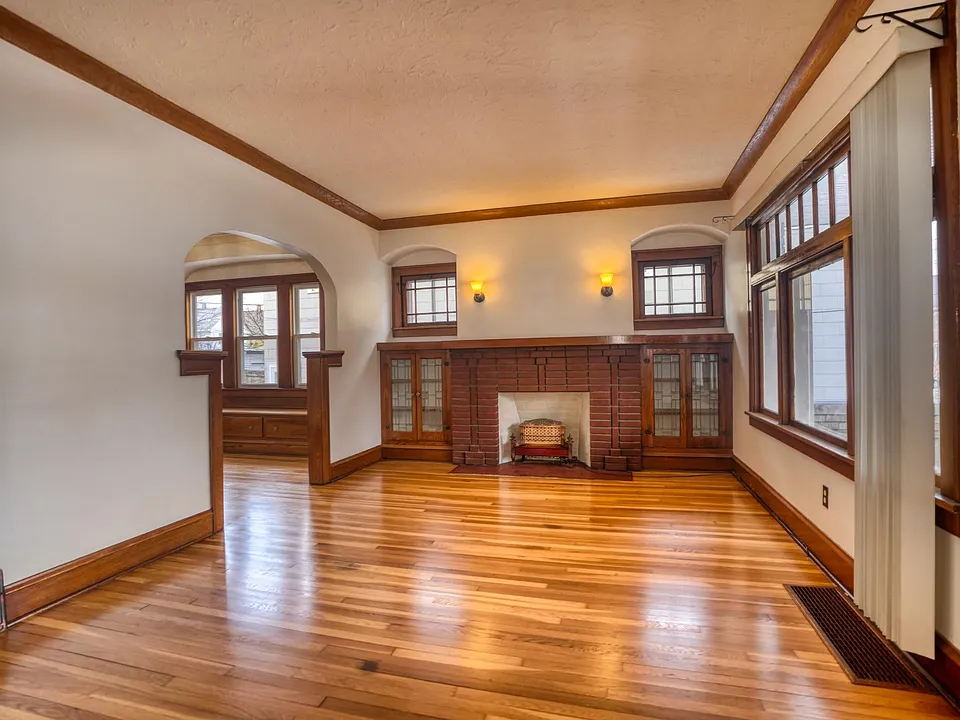 Living Room with updated lighting and built-ins, decorative fireplace, and freshly refinished original 1926 White Oak floors