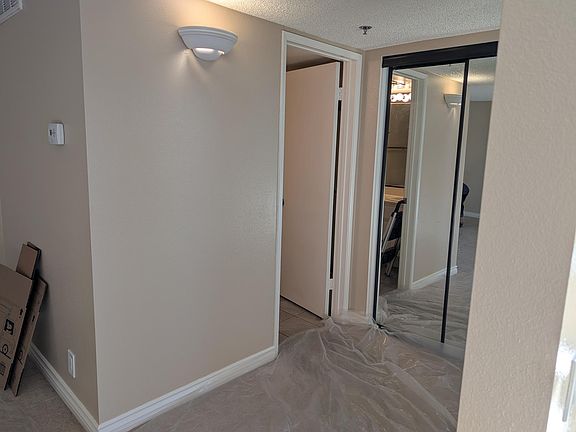 Door to bathroom and mirrored sliding closet doors.