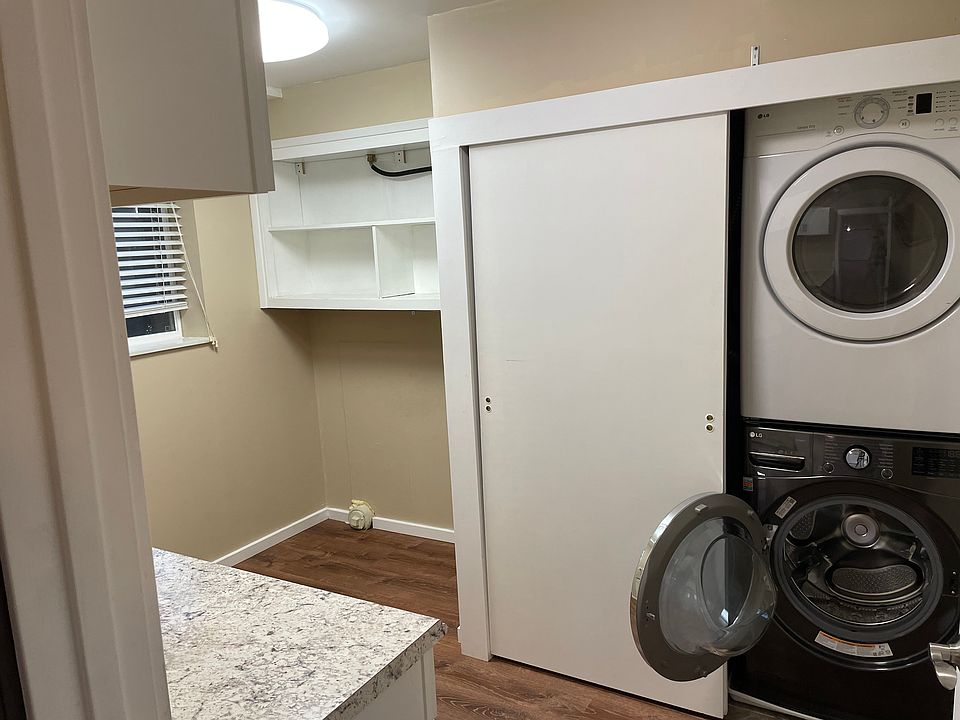 Laundry Room: stacked washer/dryer, shelving, counter space.