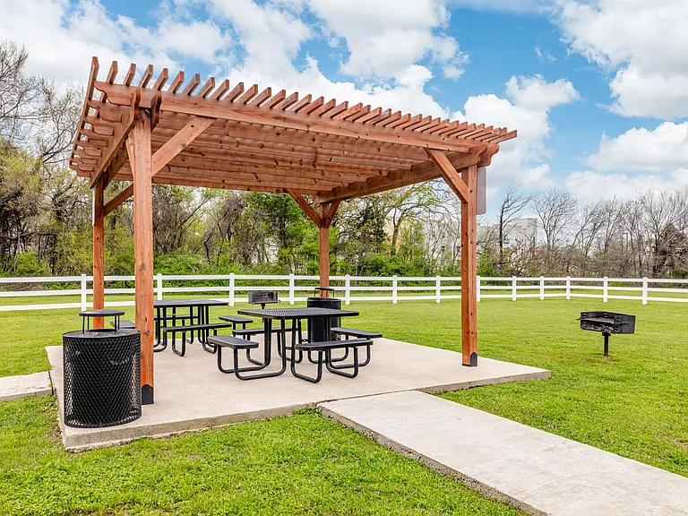 Shaded outdoor picnic area with pergola seating, perfect for relaxing or entertaining
