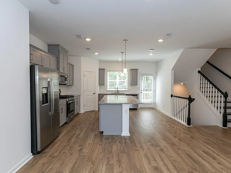 Spacious kitchen offering an elegant path to the stairwell.