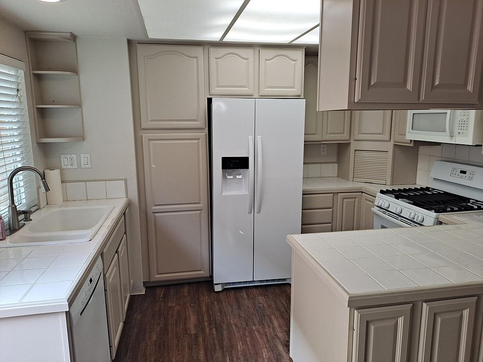 Custom Cabinetry with lots of space new side by side refrigerator with water and ice upgraded dishwasher stove microwave.