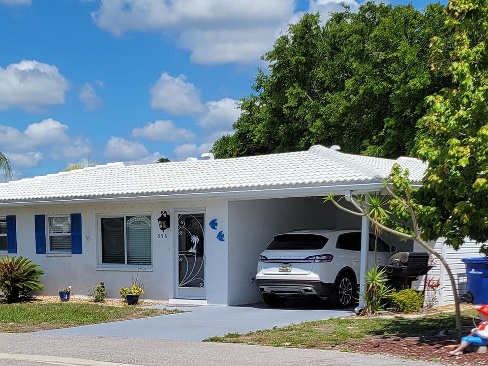 Front of condo with carport and storage cabinets