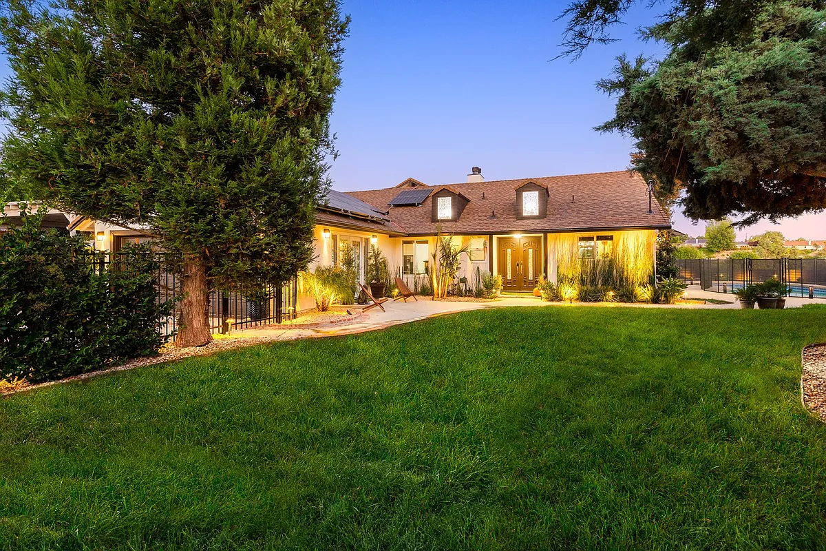 Private landscaped backyard with lush lawn and evening lighting-ideal for entertaining and family living - 7130 Gateshead Way