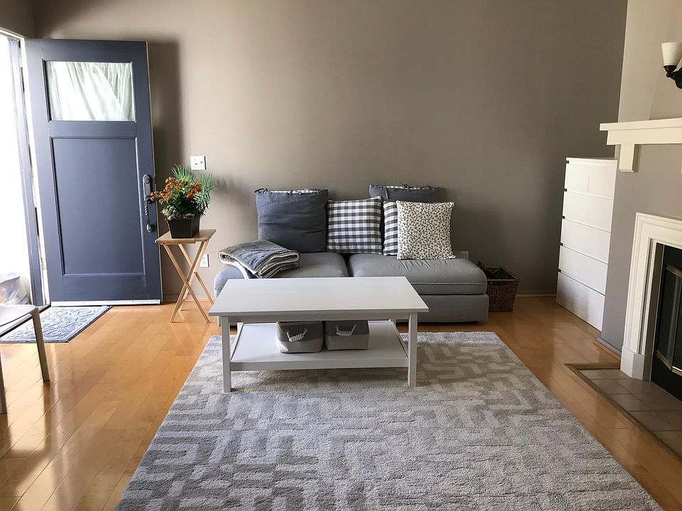 Living room with maple hardwood floor. Unit comes furnished with the sofa, coffee table, and chest of drawers pictured.