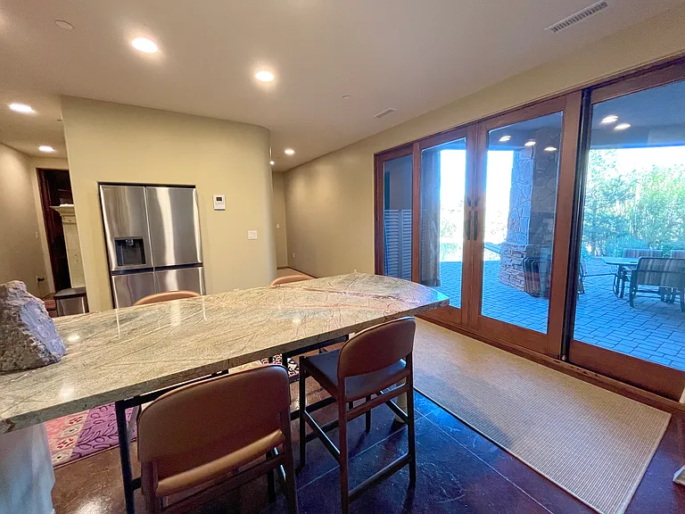 Patio Doors to Pool from Lower Kitchen and Dining Area off Media Room with Hallway to Master Suite 3 on the Right and Hallway to Elevator on the Left