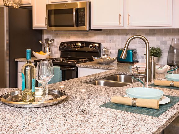 Kitchen featuring large granite counter tops and white cabinets.