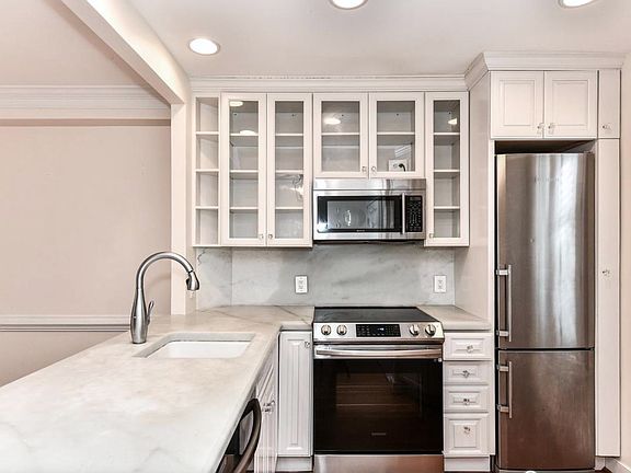 The open concept main floor is flooded with light, features hardwood floors and plantation shutters in the kitchen.