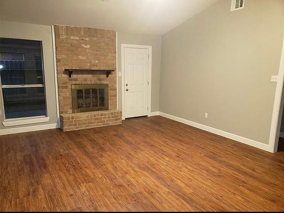 Living room fireplace with door to small side patio.