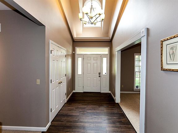 Entry foyer features custom entry door with transom window & vaulted ceiling.