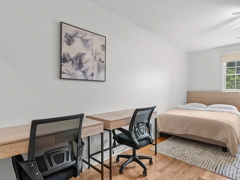 Upper-level bedroom with two full beds, two writing desks, and generous closet space.