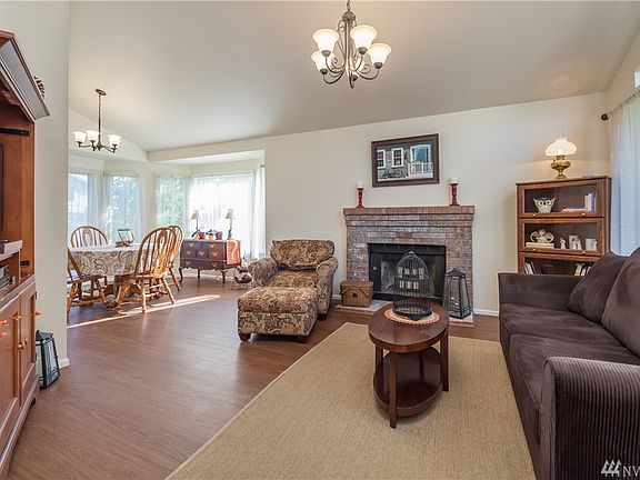 Formal living room has vaulted ceiling and a cozy fireplace