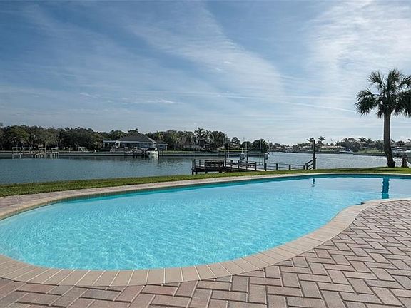 Waterside pool with pavers and dock