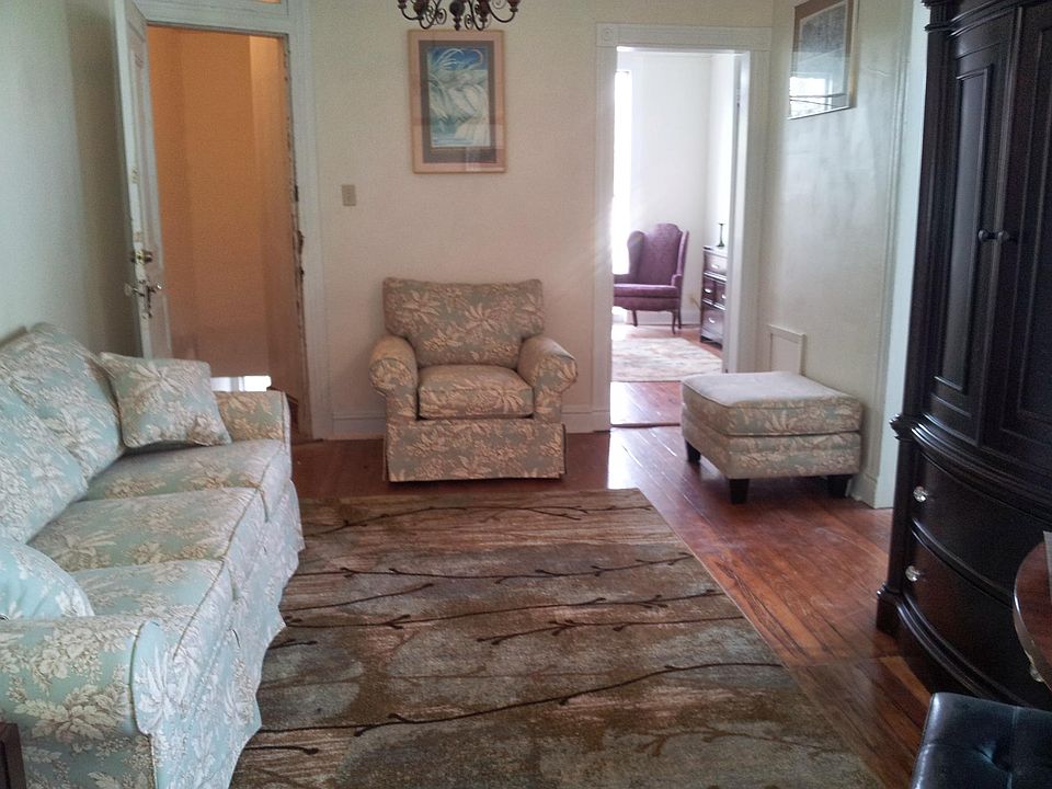 Living room. Front door open on left, looking into front bedroom.