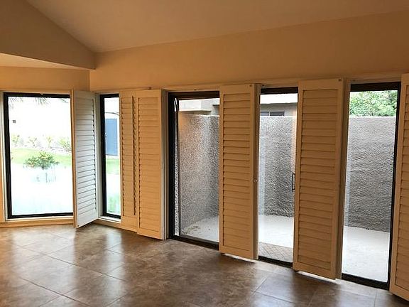 Lots of WINDOWS in living room and Dining room with Wood PLANATION Shutters