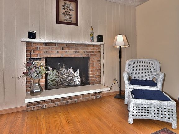 This bright cheery living room has beautiful hardwood floors, wood fireplace. Plaster ceilings give this home a mid-century appeal. 