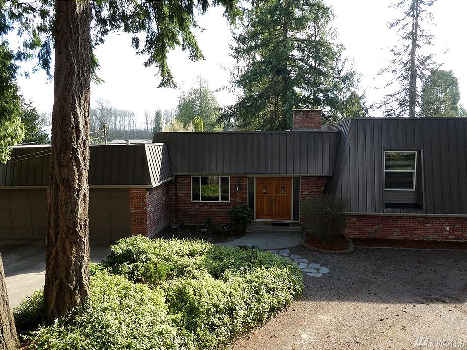 Nestled in the trees, brick exterior with metal accent.  New Commercial Grade 40 year roof installed last year