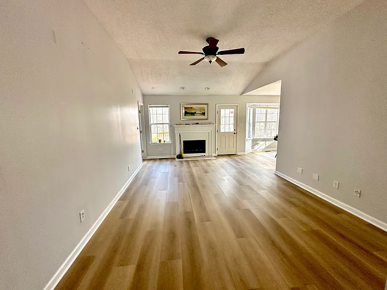 Open living area with modern flooring and ceiling fan