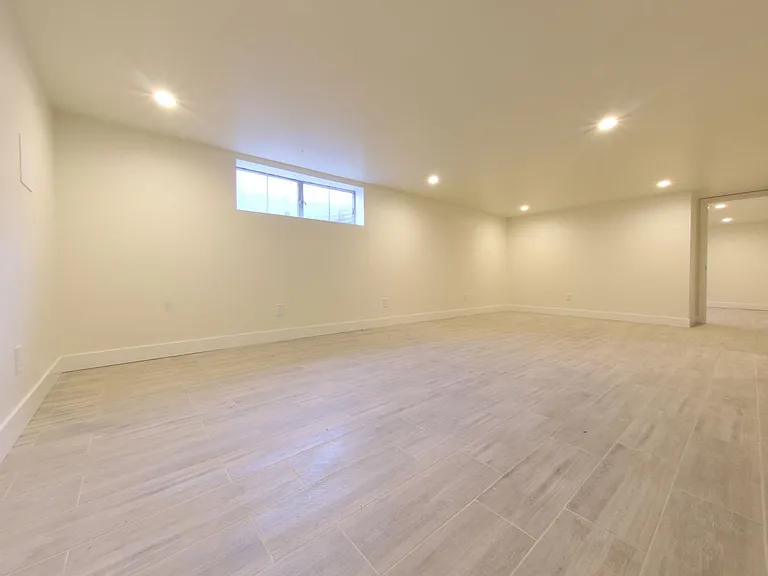 Large Basement Living area with wood tile floors and recessed lighting.