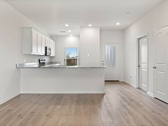 The kitchen and dining room of the Driftwood has beautiful wood-style, vinyl flooring.