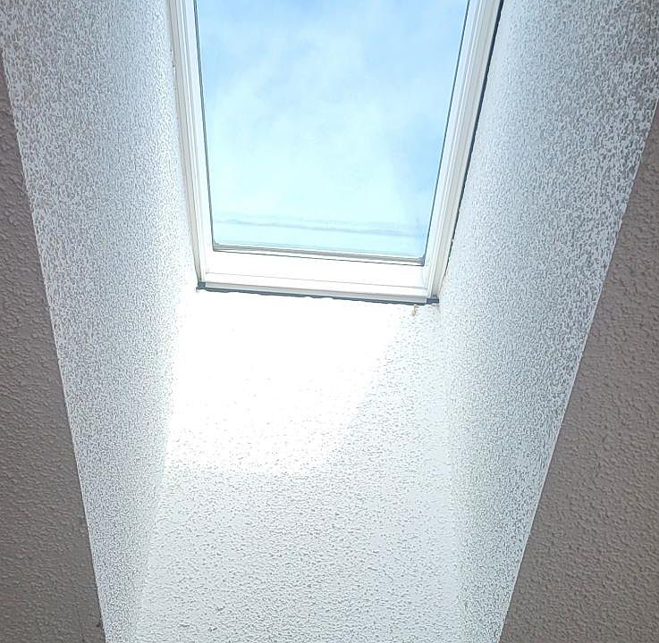 "Living room with skylights that fill the space with natural light."