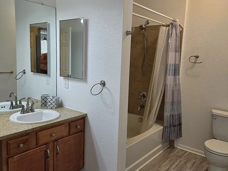 Guest bath features a soaker tub and shower with vinyl flooring
