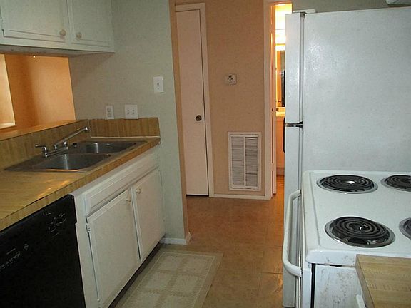 Tiled kitchen with breakfast bar and view of the dining room - living room combo. Kitchen has lots o