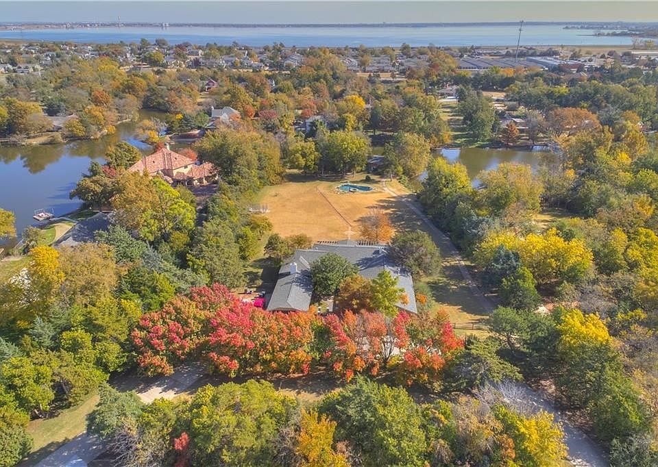 Large 2.5 acre property! The beautiful red fall leaves are the trees lining the driveway of this home. The pool is visible toward the middle of the picture, and two cabins are located in the trees, and overlooking Silver Lake. That's Lake Hefner in the ba