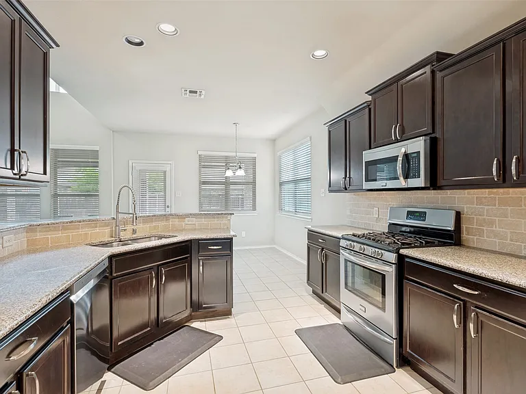 SS appliances with fridge included. Washer & dryer in separate room.