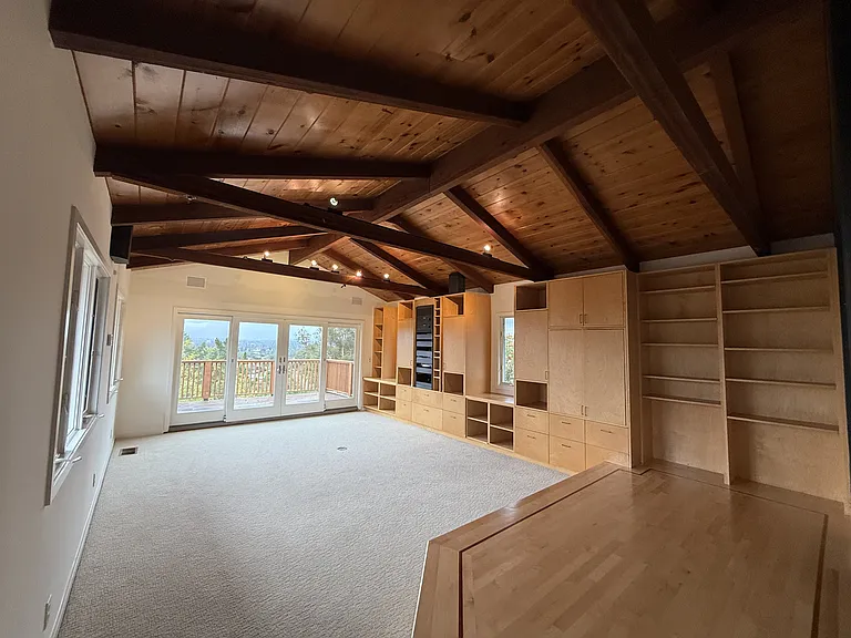 A media room features vaulted ceiling, view windows, a pull-down screen and stage.